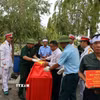 Nghi thức phủ cờ Tổ quốc lên hài cốt liệt sỹ Bùi Tiến Dũng. (Ảnh: Đoàn Mạnh Dương/TTXVN)