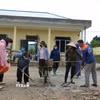 Giáo viên, phụ huynh và công nhân nhà thầu thi công chung tay, khẩn trương dọn dẹp khuôn viên điểm trường Bản Chít của Trường Mầm non Mường Than (Lai Châu). (Ảnh: Việt Dũng/TTXVN)