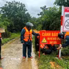 Cán bộ, chiến sỹ Bộ đội Biên phòng Quảng Trị phối hợp lắp đặt biển cảnh báo tại khu vực nước sâu, nguy hiểm, chủ động phòng ngừa tai nạn trong mùa mưa lũ. (Ảnh: TTTXVN phát)