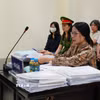 Bị cáo Nguyễn Thị Bình (đeo kính) và bị cáo Phạm Thị Minh Nguyệt (mặc áo sẫm màu, đeo khẩu trang trắng) tại phiên xử. (Ảnh: Kim Anh/TTXVN)