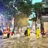 Công nhân thoát nước khơi thông dòng chảy trên phố Đội Cấn. (Ảnh: Lê Đông/TTXVN)