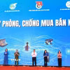 Các đại biểu thực hiện nghi thức thể hiện cam kết phòng, chống mua bán người. (Ảnh: Xuân Triệu/TTXVN