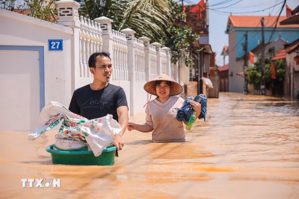 Người dân thôn Ngộ Đạo, xã Đa Phúc, Hà Nội, di chuyển tài sản khỏi vùng bị ngập. (Ảnh: Hoàng Hiếu/TTXVN)