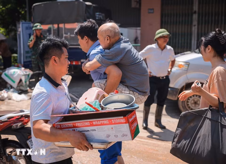 Người dân thôn Ngô Đạo, xã Đa Phúc, Hà Nội, di chuyển tài sản khỏi nơi bị ngập. (Ảnh: Hoàng Hiếu/TTXVN)