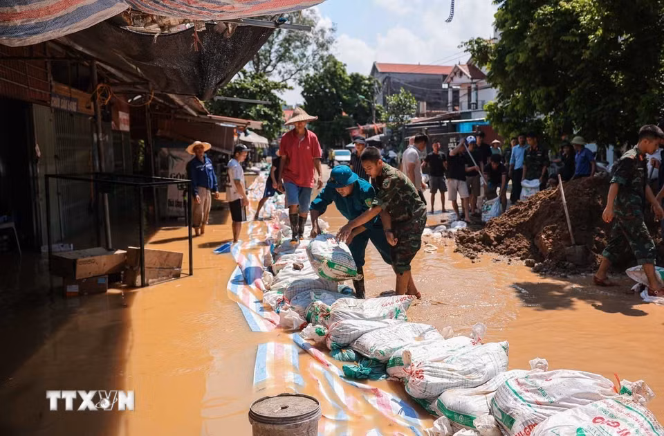 Lực lượng vũ trang Quân khu 1 cùng nhân dân thôn Ngô Đạo, xã Đa Phúc (Hà Nội) tiến hành các biện pháp gia cố đê Hữu Cầu. (Ảnh: Hoàng Hiếu/TTXVN)
