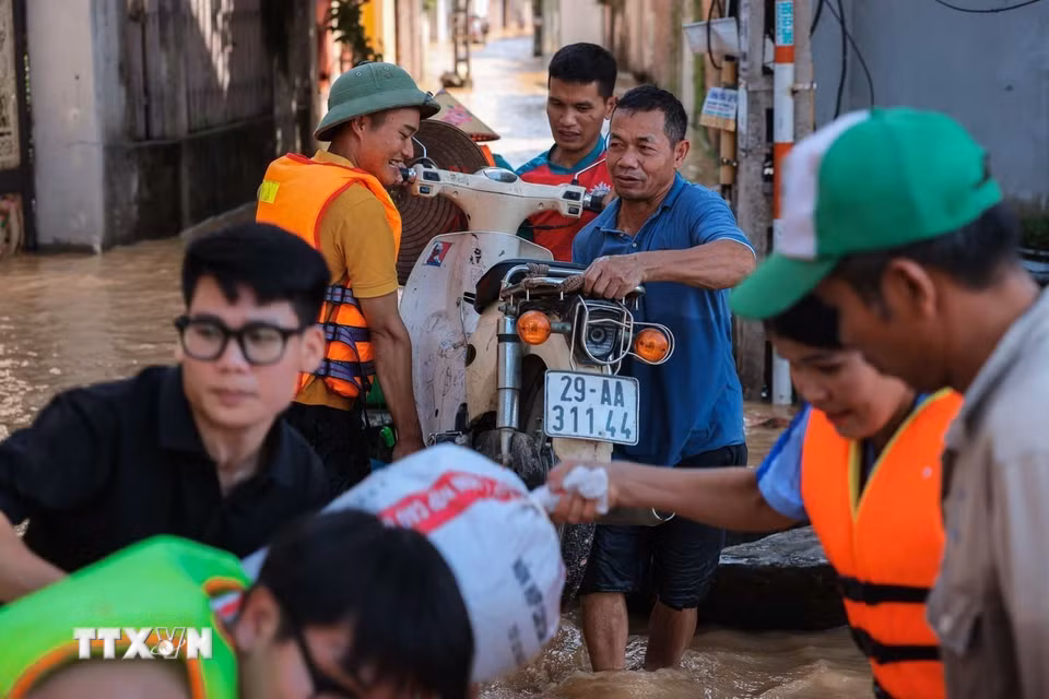Người dân thôn Ngộ Đạo, xã Đa Phúc, Hà Nội, di chuyển tài sản khỏi vùng bị ngập. (Ảnh: Hoàng Hiếu/TTXVN)