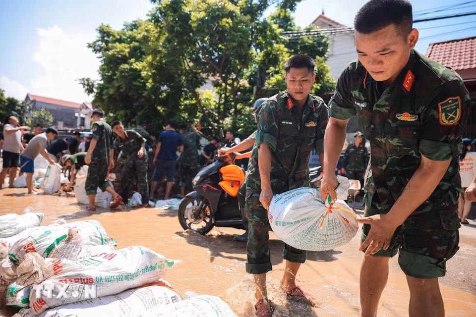 Lực lượng quân đội Quân khu 1 cùng nhân dân thôn Ngô Đạo, xã Đa Phúc (Hà Nội) đang gia cố đê Hữu Cầu. (Ảnh: Hoàng Hiếu/TTXVN)