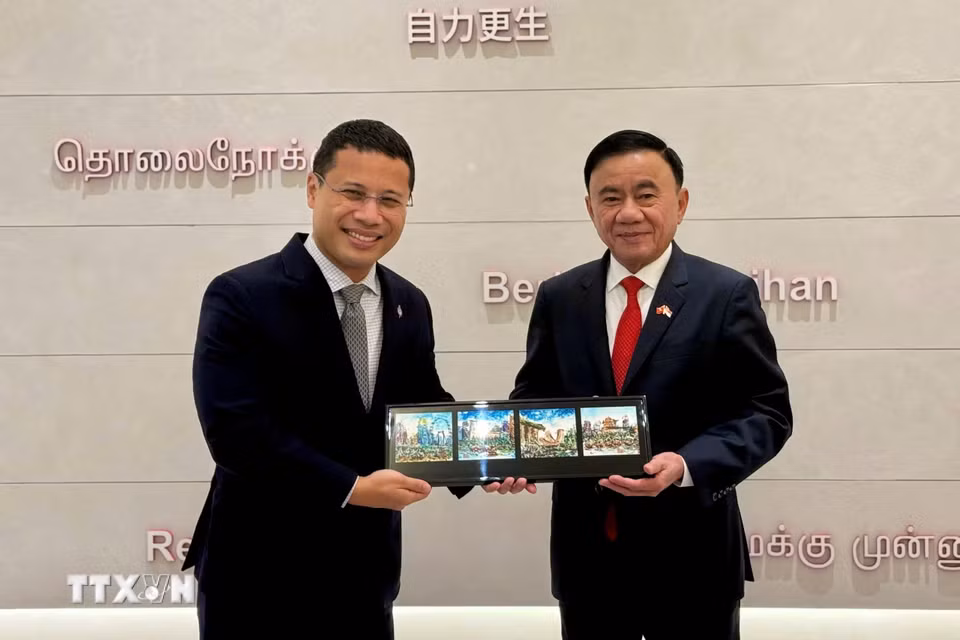 Ủy viên Bộ Chính trị, Thường trực Ban Bí thư Trần Cẩm Tú và Chủ tịch Đảng Hành động Nhân dân Singapore Desmond Lee trao tặng phẩm. (Ảnh: Phương Hoa/TTXVN)