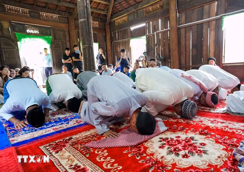 Những người đàn ông Chăm Islam mặc trang phục truyền thống, cùng nhau đến thánh đường thực hiện nghi lễ cầu nguyện. (Ảnh: Khánh Hòa/TTXVN)