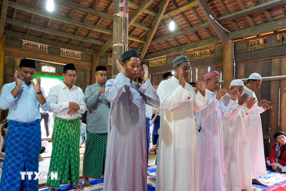 Những người đàn ông Chăm Islam mặc trang phục truyền thống, cùng nhau đến thánh đường thực hiện nghi lễ cầu nguyện. (Ảnh: Khánh Hòa/TTXVN)