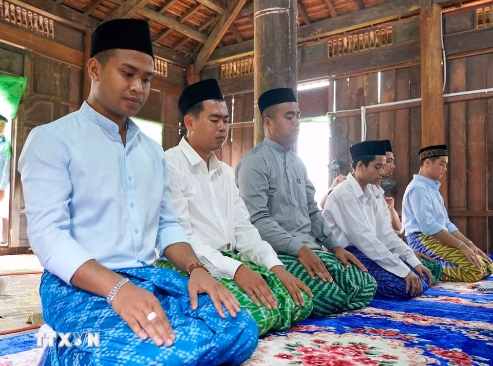 Những người đàn ông Chăm Islam mặc trang phục truyền thống, cùng nhau đến thánh đường thực hiện nghi lễ cầu nguyện. (Ảnh: Khánh Hòa/TTXVN)