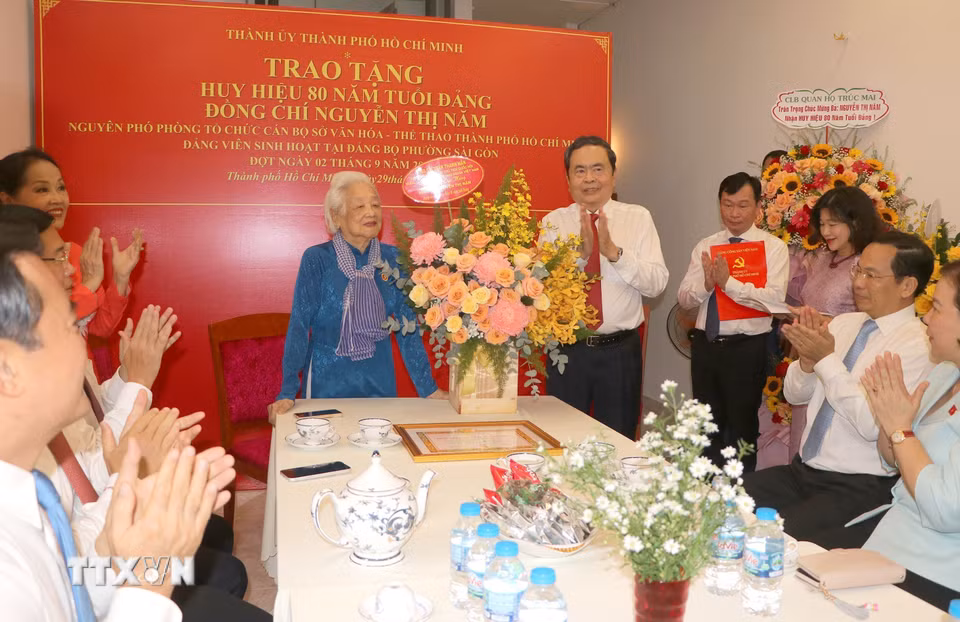 Chủ tịch Quốc hội Trần Thanh Mẫn tặng hoa chúc mừng đồng chí Nguyễn Thị Năm, Đảng bộ phường Sài Gòn, Thành phố Hồ Chí Minh. (Ảnh: Thanh Vũ/TTXVN)