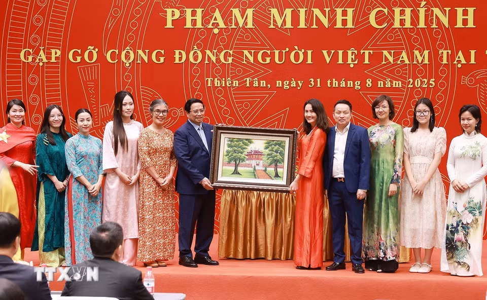 Thủ tướng Phạm Minh Chính tặng quà cộng đồng người Việt Nam tại Trung Quốc. (Ảnh: Dương Giang/TTXVN)
