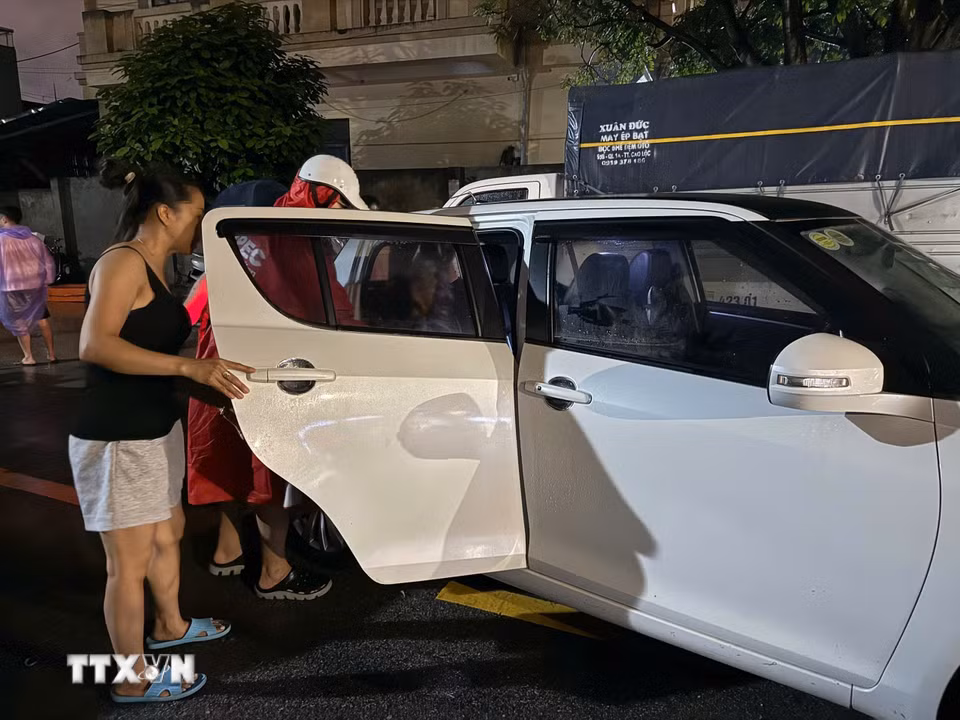 Người dân được hỗ trợ di chuyển đến nơi an toàn. (Ảnh: Tiến Vĩnh/TTXVN)