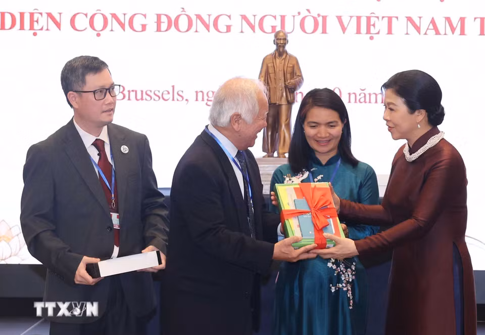 Phu nhân Ngô Phương Ly tặng sách Tiếng Việt cho Hội người Việt Nam tại Bỉ. (Ảnh: Thống Nhất/TTXVN)