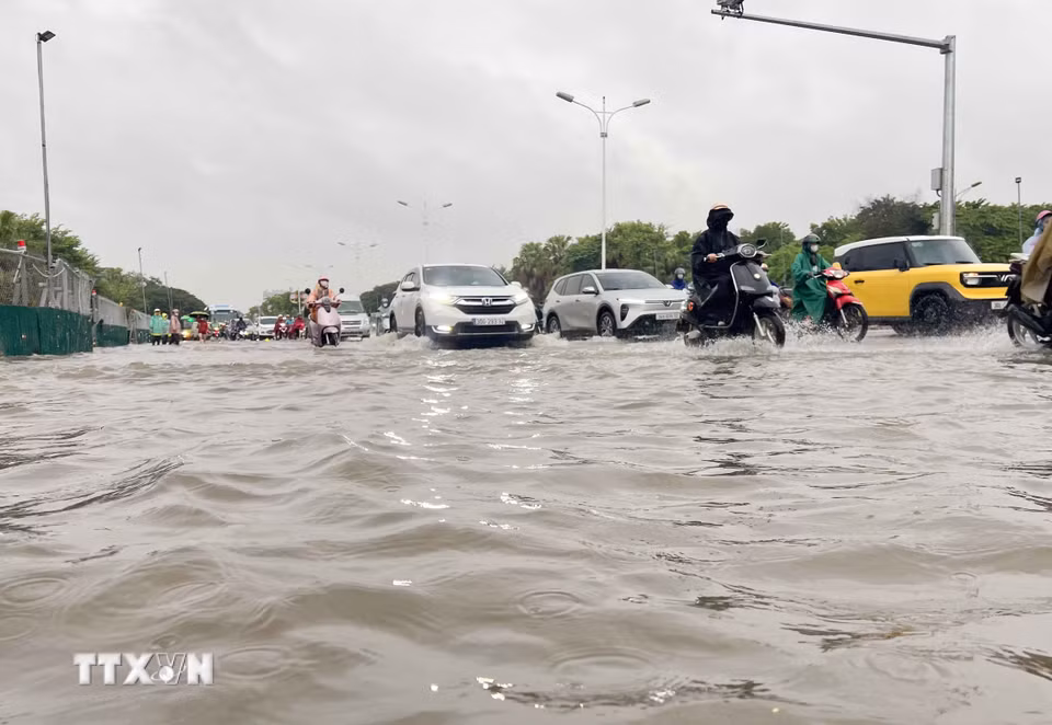 Các phương tiện nối đuôi nhau trong làn nước trên đường Đàm Quang Trung, phường Long Biên, đoạn từ cầu vượt Vĩnh Tuy đến ngã tư Cổ Linh-Đàm Quang Trung. (Ảnh: Phan Phương/TTXVN)