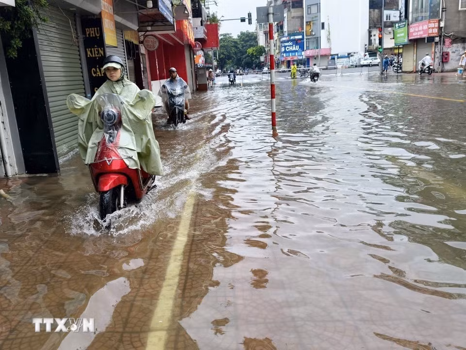 Ngập úng trên phố Ngọc Lâm, phường Bồ Đề, khiến việc đi lại của người dân gặp nhiều khó khăn. (Ảnh: Minh Quyết/TTXVN)