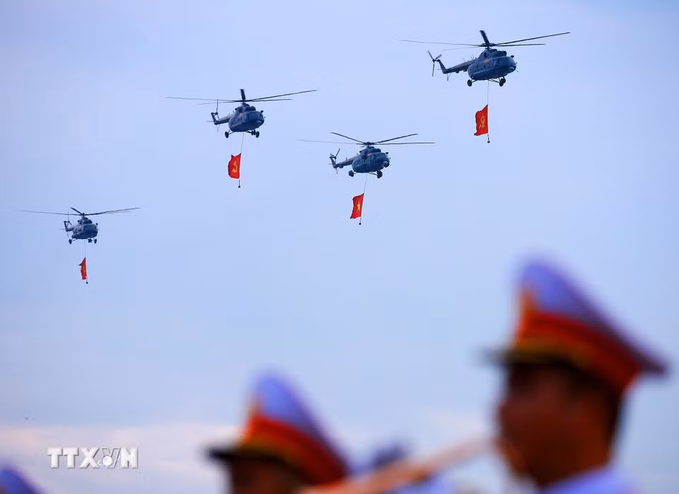 Biên đội máy bay trực thăng Mi-171, Mi-17, Mi-8 mang theo cờ Đảng, cờ Tổ quốc bay qua khu vực Quảng trường Ba Đình. (Ảnh: Dương Giang/TTXVN)