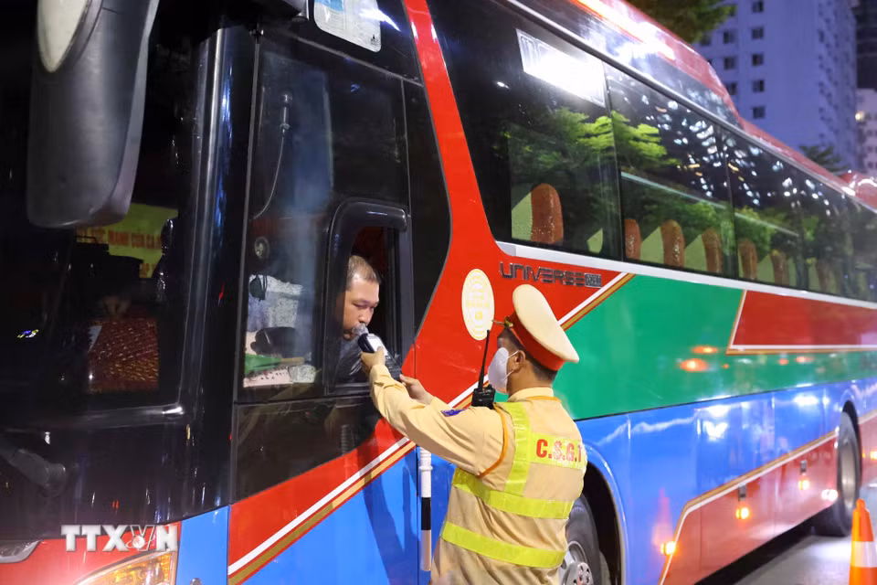 Cán bộ, chiến sỹ đội Cảnh sát giao thông số 6 kiểm tra nồng độ cồn tài xế xe khách tại tuyến phố Trần Thái Tông-Tôn Thất Thuyết. (Ảnh: Phạm Kiên/TTXVN)