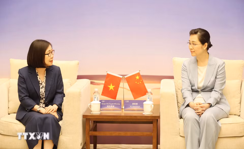 Phó Tổng Giám đốc Thông tấn xã Việt Nam Đoàn Thị Tuyết Nhung (trái) gặp và làm việc với Phó Xã trưởng Tân Hoa xã Tập Diễm Xuân. (Ảnh: Công Tuyên/TTXVN)