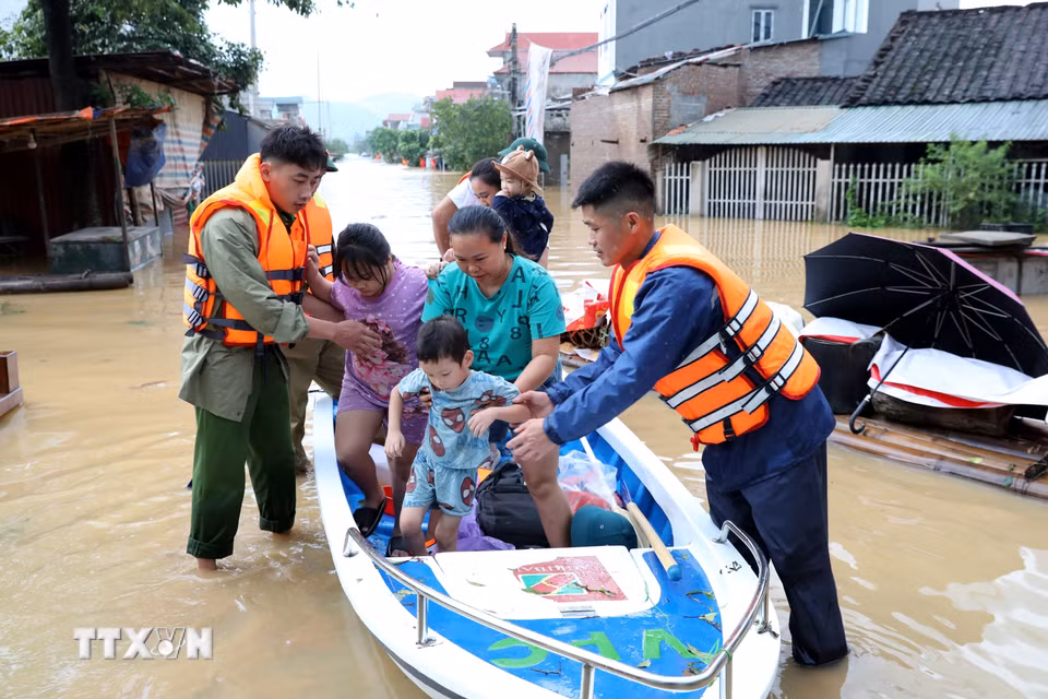 Lực lượng chức năng xã Tràng Định, tỉnh Lạng Sơn, hỗ trợ đưa người dân từ vùng ngập sâu đến nơi an toàn. (Ảnh: Văn Đạt/TTXVN)