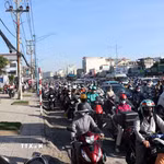 Nhiều người đi xe máy chạy lên vỉa hè để di chuyển khi đường ùn ứ. (Ảnh: Tiến Lực/TTXVN)