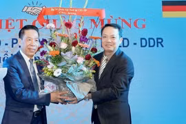 Ông Phạm Huy Phương, Bí thư thứ nhất, Thường trực ban Công tác Cộng đồng Đại sứ quán Việt Nam tặng hoa cựu cán bộ, phiên dịch và đội trưởng hợp tác lao động Việt Nam và CHDC Đức. (Ảnh: Phương Hoa/Vietnam)