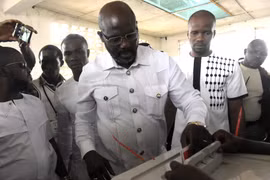Ứng cử viên Tổng thống Liberia George Weah (giữa, phía trước) bỏ phiếu tại điểm bầu cử ở Monrovia ngày 26/12. (Nguồn: AFP/TTXVN)