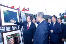 Bộ trưởng Trương Minh Tuấn cùng các quan khách đang thăm quan Triển lãm. (Ảnh: Phạm Kiên/Vietnam+)