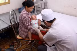 Khám cho trẻ bị mắc sùi mào gà do trước đây từng cắt bao quy đầu tạo cơ sở của bà Hoàng Thị Hiền. (Ảnh: Phạm Kiên/TTXVN)