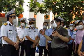 Thủ tướng Phạm Minh Chính kiểm tra về công tác theo dõi, điều trị tại khu cách ly F1 của công nhân viên chức Tân cảng Sài Gòn tại trường mầm non Sơn Ca, thành phố Thủ Đức. (Ảnh: Thanh Vũ/TTXVN)