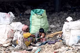 Một bà mẹ cùng các con nhặt rác tái chế tại Guwahati, Ấn Độ. (Ảnh: AFP/TTXVN)