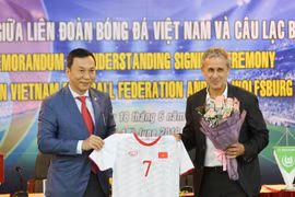 Ông Trần Quốc Tuấn; Phó Chủ tịch thường trực VFF (trái) tặng áo đấu của Đội tuyển Việt Nam cho ông Pierre Michael Littbarski, huyền thoại bóng đá Đức, Đại sứ CLB Wolfsburg. (Ảnh: Trọng Đạt/TTXVN)
