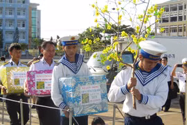 Cán bộ, chiến sỹ Vùng 2 Hải quân vận chuyển quà Tết lên tàu cho chuyến hành trình. (Ảnh: Hoàng Nhị/TTXVN)