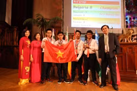 4 học sinh đoạt Huy chương Vàng gồm: Trịnh Anh Minh, Mai Nam Khánh, Nguyễn Quang Anh, Đỗ Hoàng Quốc Bảo cùng các thầy cô giáo trong đoàn Việt Nam tại Lễ trao giải IMC 2019, ngày 5/8/2019. (Ảnh: Phi Hùng/TTXVN)