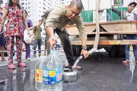 Người dân Hà Nội phải mua, hoặc nhận nước sạch để sử dụng. (Ảnh: PV/Vietnam+)