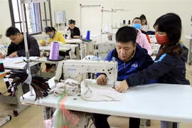 Các học viên học nghề may công nghiệp được giáo viên (là người khuyết tật) chỉ dạy tận tình tại Trung tâm dạy nghề (Hội Bảo trợ người khuyết tật và Bảo vệ quyền trẻ em tỉnh Thái Bình). (Ảnh: Thế Duyệt/TTXVN)