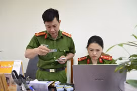 Trả căn cước công dân gắn chip điện tử cho người dân. (Ảnh: Xuân Tư/TTXVN)
