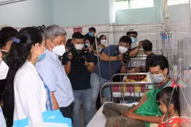 Thứ trưởng Bộ Y tế Nguyễn Trường Sơn kiểm tra công tác thu dung, điều trị bệnh nhân sốt xuất huyết tại Bệnh viện quận 8, Thành phố Hồ Chí Minh. (Ảnh: Đinh Hằng/TTXVN)
