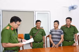 Đại diện Cơ quan Cảnh sát điều tra Công an tỉnh thi hành lệnh bắt tạm giam Nguyễn Văn Cuộc. (Ảnh: TTXVN phát)