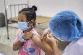 Nhân viên y tế xã Tản Lĩnh tiêm vaccine phòng COVID-19 cho học sinh trường Tiểu học Tản Lĩnh, Hà Nội. (Ảnh: Tuấn Đức/TTXVN)