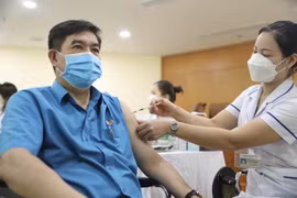 Cán bộ, công chức, viên chức và người lao động hưởng ứng tiêm vaccine mũi nhắc lại trong ngày phát động. (Ảnh: Minh Quyết/TTXVN)