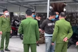 Đối tượng Trần Quang Minh (áo đen) bị bắt tại hiện trường. (Ảnh: TTXVN phát)