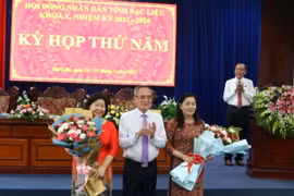 Chủ tịch Hội đồng Nhân dân tỉnh Bạc Liêu Lữ Văn Hùng tặng hoa cho 2 đại biểu thôi tham gia Hội đồng Nhân dân tỉnh khóa X, trong đó có bà Cao Xuân Thu Vân. (Ảnh: Tuấn Kiệt/TTXVN)