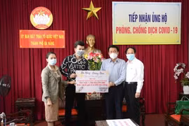 Đại diện Ban tổ chức chương trình trao tặng số tiền và hiện vật cho đại diện thành phố Đà Nẵng. (Ảnh: Quốc Dũng/TTXVN)
