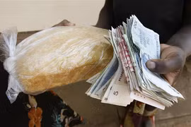 Người dân trả tiền để mua bánh mì tại Harare, Zimbabwe. (Ảnh: AFP/TTXVN)