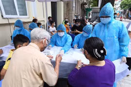 Người về từ Đà Nẵng làm thủ tục xét nghiệm nhanh tại phường Bách Khoa và phường Cầu Dền (quận Hai Bà Trưng, Hà Nội). (Ảnh: Minh Quyết/TTXVN)