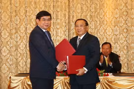 Ông Lienthikeo, Bộ trưởng Tài chính Lào và ông Phan Đức Tú, Tổng Giám đốc BIDV tại buổi ký kết. (Ảnh: Phạm Kiên/Vietnam+)