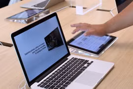 Khách hàng trải nghiệm máy tính MacBook tại cửa hàng của Apple tại Rosny-sous-Bois, gần Paris, Pháp. (Ảnh: AFP/TTXVN)