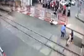 Hai nhân viên gác chắn dũng cảm quên mình cứu cụ bà thoát chết ngay trước khi đoàn tàu lao tới. (Ảnh: Trích từ camera an ninh)
